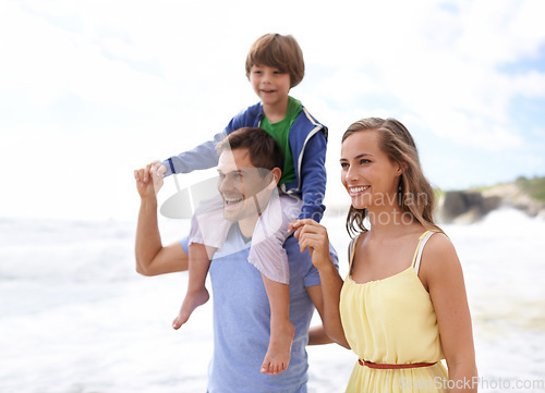 Image of Family, fun and happy while walking at beach for travel, fun or holiday in summer with a smile. Man, woman and child or son walk together outdoor on vacation at sea with happiness, love and care