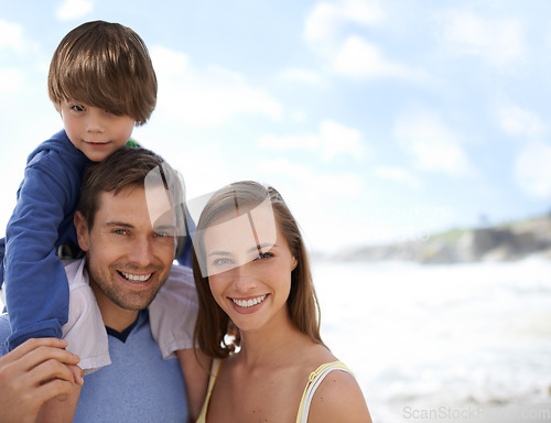 Image of Happy family, portrait and blue sky at beach on travel, holiday or vacation in summer with a smile. Man, woman and child together on adventure or quality time at sea with happiness, love and care