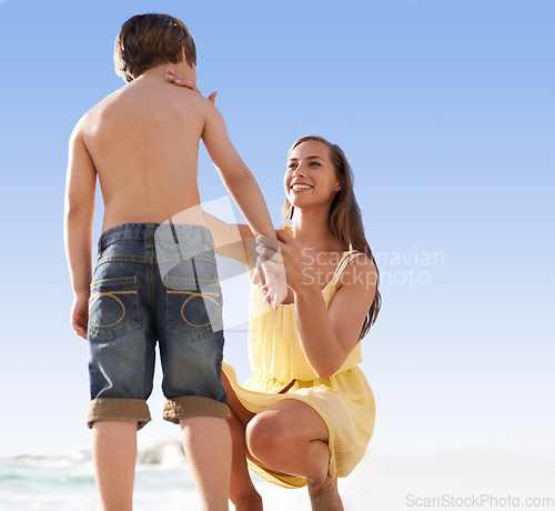 Image of Mother, child or family at beach with sunscreen lotion on body for sun protection on travel or holiday in summer. A woman and kid or son together on vacation at sea with blue sky, cream and happiness