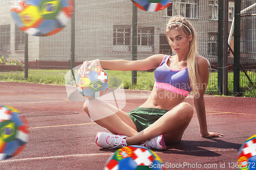 Image of woman in sportswear with football ball
