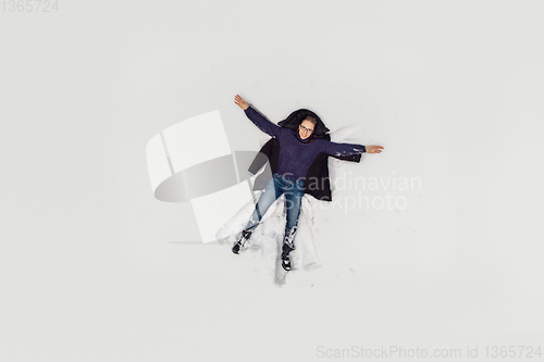 Image of Aerial view to woman lying in snow