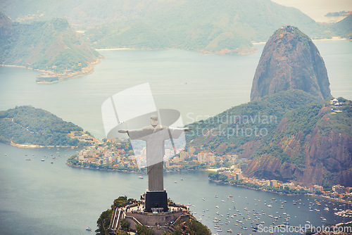 Image of Statue, monument and Christ the Redeemer on mountain for tourism, sightseeing and travel destination. Traveling, Rio de Janeiro and aerial view of symbol, sculpture and city landmark by Brazil ocean