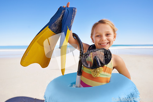 Image of Beach, portrait and girl child with flippers, snorkel and inflatable swimming ring on ocean background. Face, happy and kid swimmer smiling, excited and ready for adventure while traveling in Miami