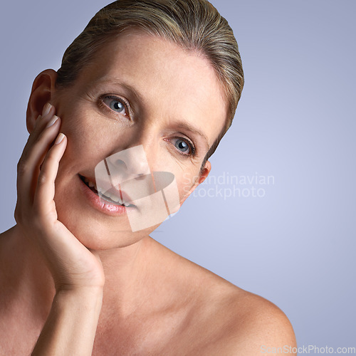 Image of Face, beauty and mature woman with skincare or cosmetic facial isolated in a blue studio background. Cosmetics, self care and old female model calm with natural skin due to anti aging dermatology