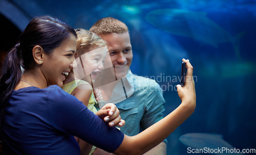 Image of Aquarium, happy and family selfie by fish on vacation, holiday and trip together. Photo, fishtank and father, mother and girl taking pictures for memory, social media or profile picture in oceanarium
