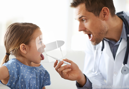 Image of Child, doctor and thermometer in clinic for medical risk of covid infection, flu and fever. Pediatrician, sick girl kid and testing temperature in mouth for disease, healthcare assessment and virus