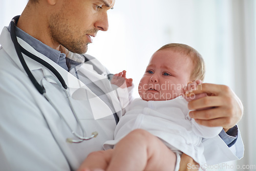 Image of Doctor, pediatrician and crying baby in clinic for medical assessment, support and growth. Sad, scared and sick newborn kid with pediatrics physician for healthcare service, hospital test or wellness