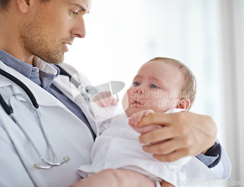 Image of Doctor, sick and sad baby in clinic for healthcare assessment, pediatrics support and help. Pediatrician holding unhappy newborn kid for hospital service, medical test and wellness of crying children