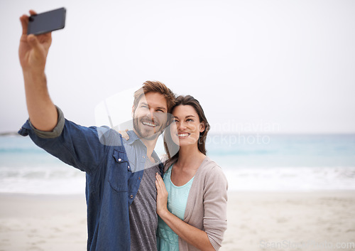 Image of Love, selfie and couple hug at beach for travel, photo and freedom outdoors together. Smile, embrace and traveling influencer people live streaming for blog, followers or social media profile picture