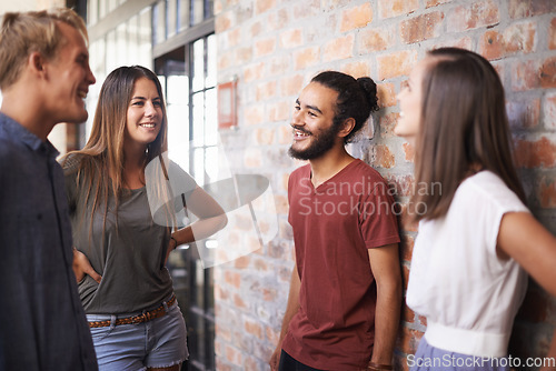 Image of Happy, friends and students talking together in a hallway for discussion, learning or a chat. Diversity group of women and men at campus or university to talk about education, project or school work