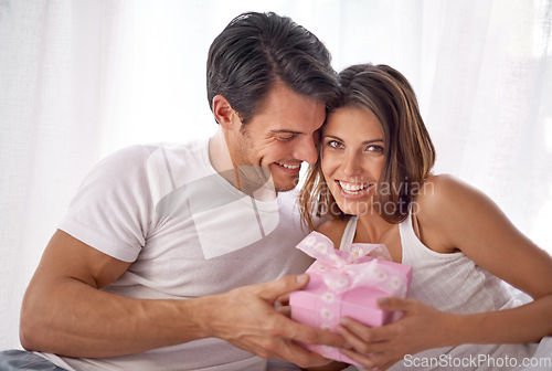 Image of Couple, gift or hug for valentines day portrait celebration with love, care and surprise in bedroom. Man and happy woman in home with box for birthday, holiday or luxury with smile for gratitude