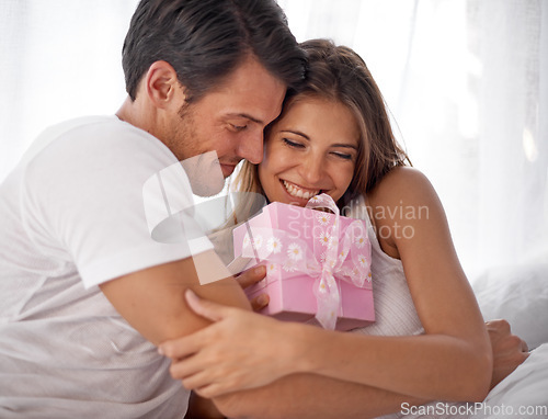Image of Gift, hug and couple for valentines day love celebration with care and surprise in bedroom. Man and woman in happy home with box for birthday, holiday or luxury present with smile for gratitude