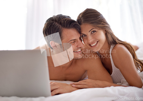 Image of Laptop, love and happy couple lying in bed together while watching a online movie or video at home. Happiness, smile and portrait of a woman browsing the internet on computer with husband in bedroom.