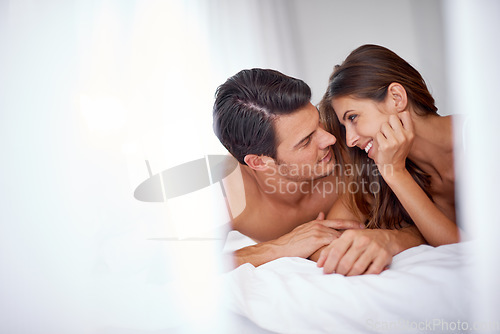 Image of Intimate, love and couple in the bedroom for conversation, relaxing and honeymoon in a hotel. Bonding, happy and young man and woman lying on a bed after valentines day, anniversary or a date