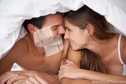 Image of Happy, love and couple in bed, waking up and bonding in a bedroom together, flirting and romantic. Romance, man and woman relax, intimate and resting at house for valentines day, anniversary or bond