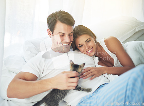 Image of Bedroom love, pet cat and happy couple relax for morning peace, calm and bonding quality time together in Toronto Canada. Flare, animal kitten and romantic people smile in home bed for Valentines Day