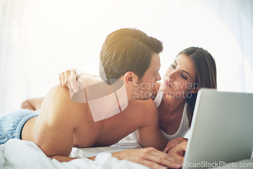 Image of Couple with laptop, streaming film and relax at home with technology, wifi and happy with chill Valentines day date. Love, commitment and relationship with man and woman in bedroom with subscription