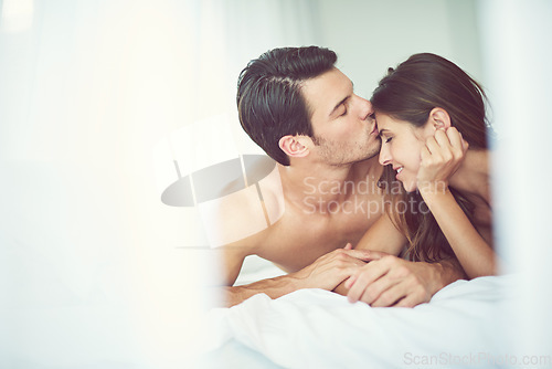 Image of Romantic, love and man kissing his wife in the morning after an anniversary, date or intimate time in bed. Gratitude, relax and young couple in the bedroom showing care and bonding for valentines day