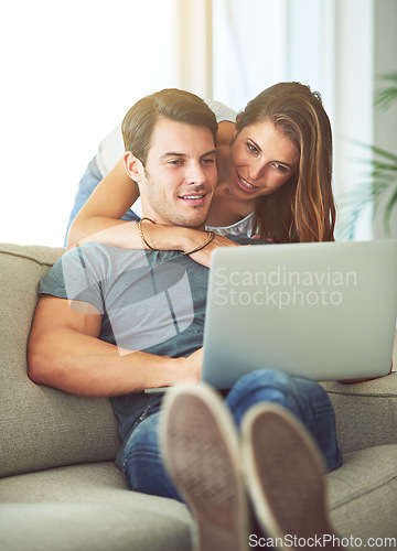 Image of Couple, laptop and hug on home sofa while on internet for remote work or streaming movies. A man and woman together in a house while happy about online shopping, search or internet connection