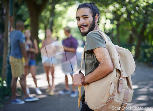 Image of Man walking, student and portrait with backpack by a campus park with a smile and ready for study. Happiness, young and male face in college and university outdoor with education and school bag