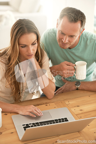 Image of Laptop, home planning and couple reading or scroll on internet together for online, website or application at table. Mature partner, woman or people on computer or pc, coffee or tea in the morning