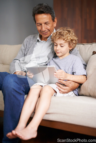 Image of Tablet, child or grandpa streaming movie or film on online subscription in retirement at home to relax. Family, grandfather or kid loves watching fun videos with a senior or mature old man on sofa