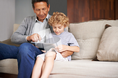 Image of Tablet, child or grandfather typing on online to search for games on internet in retirement at home to relax. Grandparent or young kid enjoying watching videos with a senior or mature old man on sofa