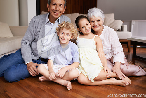 Image of Portrait, floor and happy grandparents with children, sit and smiling together in retirement family home. Senior grandma, smile or kids siblings relaxing or bonding to enjoy quality time with old man