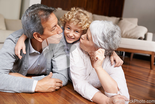 Image of Floor, portrait or grandparents kiss a happy kid playing or hugging with love or care in family home. Smile, grandma or old man relaxing or bonding to enjoy time with child or cute boy in retirement