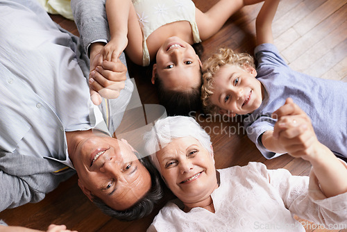 Image of Portrait, holding hands or grandparents on the floor with happy kids smiling together in family home. Grandma in retirement, relax or fun children siblings bonding to enjoy quality time with old man