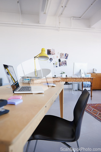 Image of Empty office, startup or laptop on wooden table in workplace, company or workspace for business. Background, modern interior design or closeup of furniture with nobody or chair in digital agency