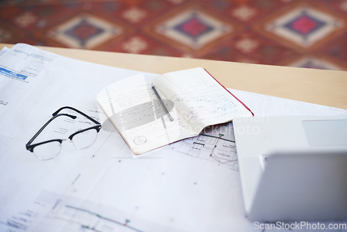 Image of Notebook, laptop and blueprint on desk for architecture planning, strategy or layout at the office. Paperwork for building or floor plan of architect construction notes, ideas or design on workspace