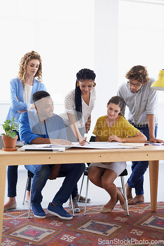 Image of Diversity, business people and blueprint in meeting for planning, construction or strategy at the office. Architect group working together on document in collaboration for floor plan at the workplace