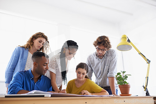 Image of Diversity, business people and documents in planning, brainstorming or design strategy at the office. Group of diverse employees working together on paperwork in teamwork collaboration at workplace