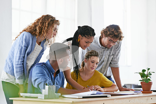 Image of Diversity, business people and writing in meeting for collaboration, planning or strategy at the office. Group of diverse employees working on paperwork, documents or team brainstorming at workplace