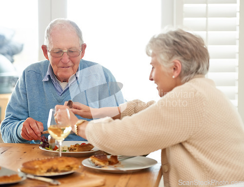 Image of Love, help and senior couple eating lunch together in the dining room of their modern home. Happy, date and elderly man and woman in retirement talking, bonding and enjoying meal or food in a house.