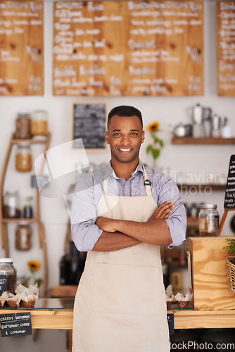 Image of Black man, portrait and barista with arms crossed in cafe with pride for career or job. Waiter, smile and confidence of African person from Nigeria in restaurant, small business and coffee shop.