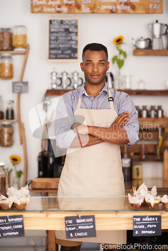 Image of Black man, portrait and waiter with arms crossed in cafe with pride for career or job. Barista, serious and confidence of African person from Nigeria in restaurant, small business and coffee shop.