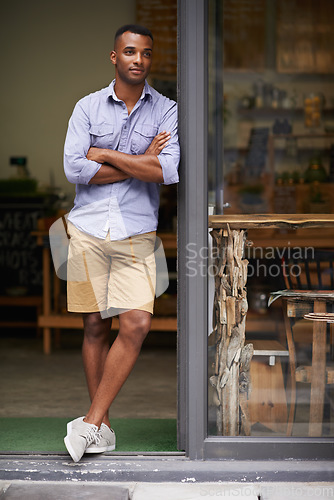 Image of Coffee shop, arms crossed and man as small business owner at door thinking of future ideas. African entrepreneur, manager or restaurant waiter with smile for service, career pride and confidence