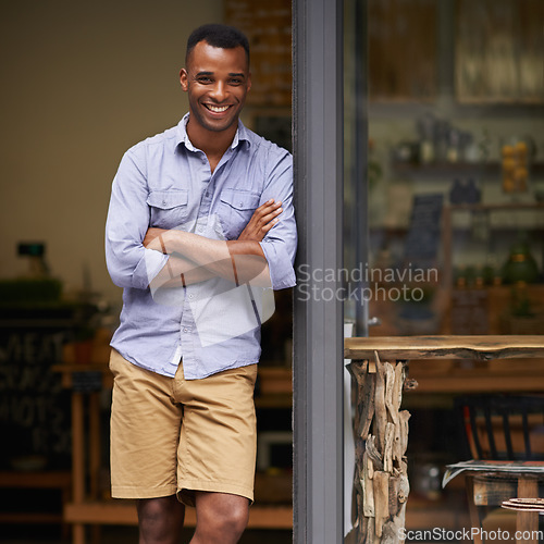 Image of Portrait, coffee shop and black man as small business owner at front door with a smile. Entrepreneur person as barista, manager or waiter in restaurant for service, career pride and startup goals