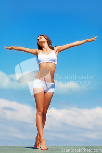 Image of Blue sky, stretching arms and body of woman in underwear for fitness, freedom and achievement of health goals. Mockup, happiness and model on roof with sunshine space, healthy mindset and celebration