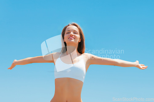 Image of Sky, smile and stretching arms and woman in underwear for fitness, freedom and health goals achievement. Mockup, happiness and model with sunshine, healthy mindset and celebration on blue background.