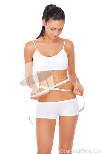 Image of Woman, fitness and tape measure for lose weight, diet or waist against a white studio background. Fit or slim female model in underwear or lingerie measuring healthy body or figure for wellness