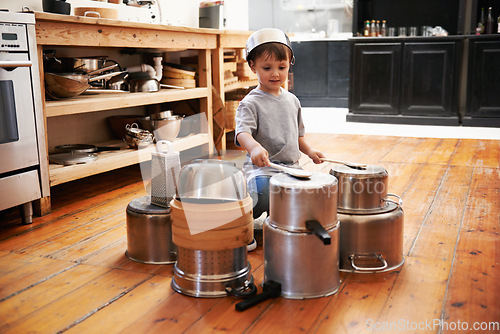 Image of Sound, boy and child on drums or pots on a floor, happy and playing fun music in house. Smile, creative or kid with pans for musical entertainment, silly or enjoying game in a kitchen on the weekend