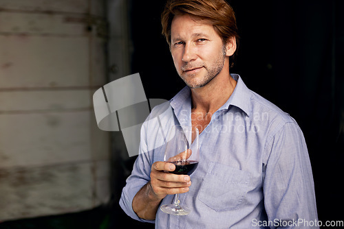 Image of Portrait, wine tasting and a man in the cellar of a vineyard on a farm for the production or fermentation of alcohol. Glass, distillery and a male farmer drinking a beverage for quality control