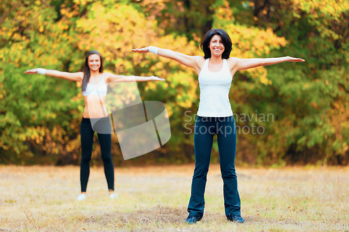 Image of Women, arm stretching and portrait in a outdoor park for yoga and fitness. Health, wellness and arms exercise of female friends in nature on grass feeling happy with smile from body and sport