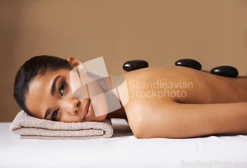 Image of Portrait of girl, rock or back massage in spa to relax for zen, resting or wellness physical therapy. Face of female client in salon to exfoliate for natural skincare healing treatment or hot stone