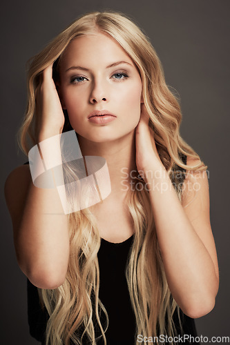 Image of Hair, beauty and face portrait of a woman with makeup, cosmetics and shine in studio. Headshot of a female aesthetic model with a skin glow, luxury haircare or hairdresser style on a grey background