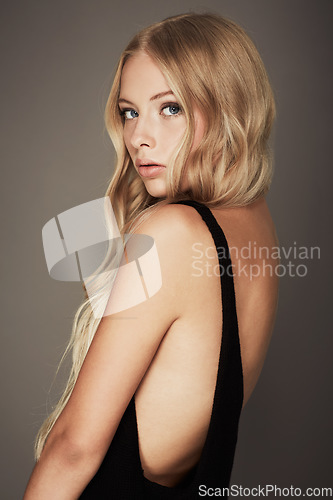 Image of Seductive, face and beauty portrait of a woman with makeup, cosmetics and long hair in studio. Headshot of a female aesthetic model with a skin glow, luxury skincare and fashion on a grey background