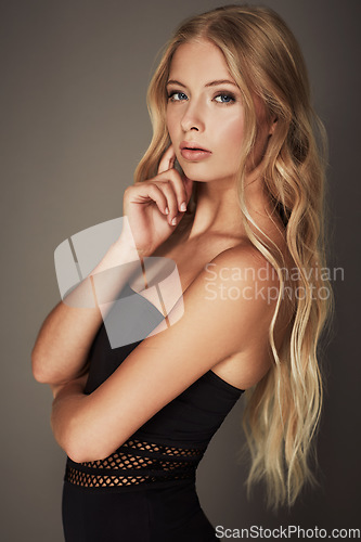 Image of Beauty, face and portrait of a woman in studio with makeup, cosmetics and long hair. Headshot of a female aesthetic model with a natural glow, sexy style and seductive pose on a grey background